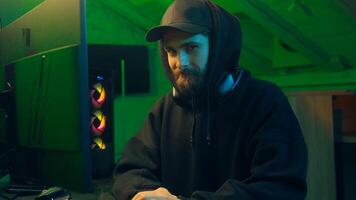 Hands typing keyboard computer Caucasian man programmer hacker looking at camera wink guy ai server system virus dangerous hooded male security hacking pc attacking code scam cyber password connection photo