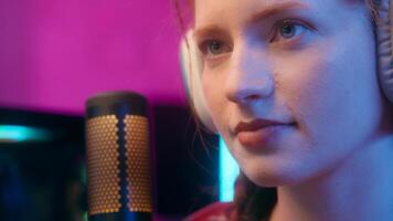 Close up Caucasian woman girl streamer gamer cyber gaming addiction female blogger influencer programmer coder look computer play game record radio podcast headphones online stream neon studio photo