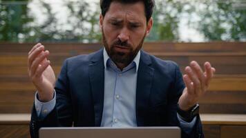 Caucasian businessman guy male entrepreneur remote work using pc laptop outdoors frustrated sad anxious stressed business man computer error crash breakdown tech problem failure scam bad news in city photo