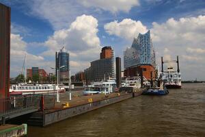 HAMBURG, GERMANY - JUNE 27 2021 Various ships landing at the port of Hamburg. The famous Elbphilharmonie can be seen in the background photo