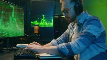 Exausta caucasiano cara criptografia comerciante corretor homem trabalhando hora extra atrasado noite cansaço. masculino trabalhador bocejar negociação estoque data limite às casa néon trabalhador autonomo digitando computador Programas excesso de trabalho programação video