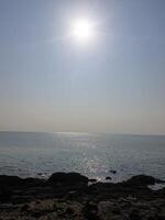 Sunlit seascape tranquil ocean view coastal area nature photography bright atmosphere serene ambiance photo