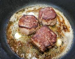 filet steak in a frying pan photo