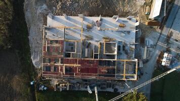 An aerial view captured by a drone showcasing the ongoing construction of a modern building, highlighting the work on the structure, scaffolding, and machinery on site photo