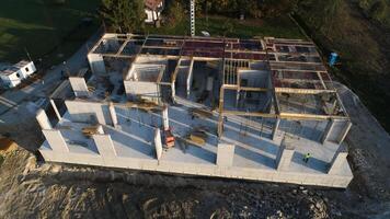 un aéreo ver capturado por un zumbido exhibiendo el en marcha construcción de un moderno edificio, destacando el trabajo en el estructura, andamio, y maquinaria en sitio foto