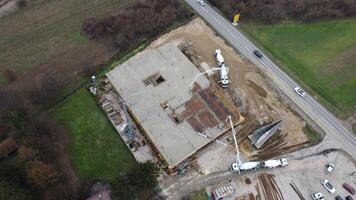 An aerial view captured by a drone showcasing the ongoing construction of a modern building, highlighting the work on the structure, scaffolding, and machinery on site photo