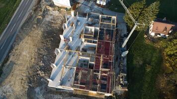 un aéreo ver capturado por un zumbido exhibiendo el en marcha construcción de un moderno edificio, destacando el trabajo en el estructura, andamio, y maquinaria en sitio foto