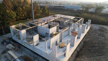An aerial view captured by a drone showcasing the ongoing construction of a modern building, highlighting the work on the structure, scaffolding, and machinery on site photo
