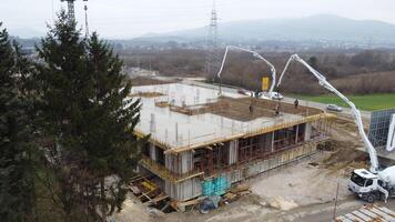 An aerial view captured by a drone showcasing the ongoing construction of a modern building, highlighting the work on the structure, scaffolding, and machinery on site photo