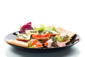 small snack canapes with crackers and lightly salted red fish Salmon, isolated on white background photo