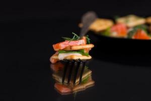 small snack canapes with crackers and lightly salted red fish Salmon, isolated on black background photo