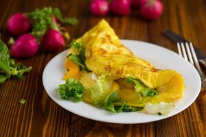 egg roll with sweet pepper and salad, on a wooden table photo
