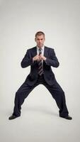Businessman in suit assumes a martial arts stance with fists ready, blending corporate professionalism with action. Competition and strategy concept photo