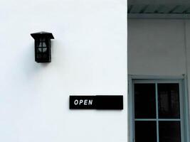 A white building with a black sign on the side photo