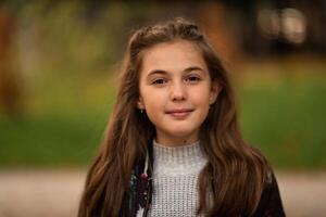 Portrait of a happy child girl outside looking at camera and smiling. photo