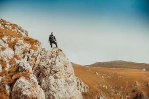 A man who hikers enjoys break a look at the mountain peak cliff. photo