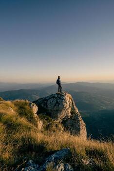 A man who hikers enjoys a break look at the top of the mountain, adventure travel. photo