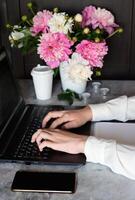 A woman is working on her laptop.She is using a pencil to write on the screen. photo