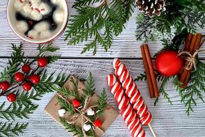 A Christmas card adorned with toys, fir branches, and a garland, complemented by decorations of sweets and cinnamon. photo