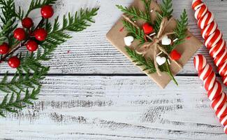 A brown, wrapped gift with green sprigs of greenery on top is in the bottom right corner of the image. photo