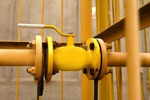 yellow gas pipe with a crane goes along the facade of a new multi-storey building. House connected to gas for domestic use photo
