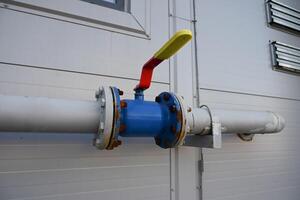 blue gas pipe with a crane goes along the facade of a new multi-storey building. House connected to gas for domestic use photo