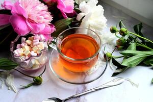 A cup of tea and cookies for breakfast with flowers. photo
