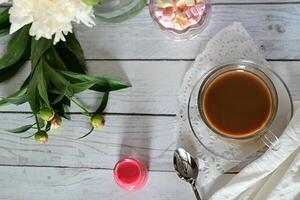 A tray with a cup of coffe and honey with flowers. photo