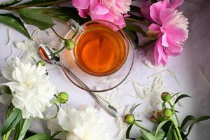 Concept of spring. Buquet of white and red piones. A cup of tea. photo