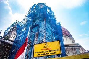 The Blenduk Church in Kota Lama Semarang is undergoing renovation, showcasing its historical architecture wrapped in scaffolding and blue netting, Indonesia, 16 November 2024 photo