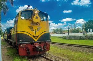 A vintage yellow locomotive D301 is captured on a bright sunny day, showcasing its classic design and historical significance. Indonesia, 17 November 2024 photo