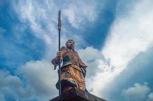 A majestic statue of a warrior holding a spear stands tall, symbolizing strength and heritage, often associated with Lunar or Chinese New Year celebrations. Indonesia, 17 November 2024 photo