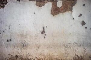 Old, weathered wall with peeling paint and exposed brick, showing signs of decay and neglect, perfect for backgrounds or textures photo