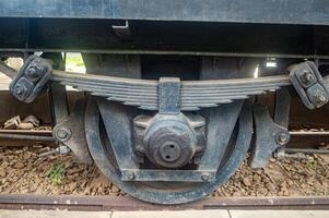 Close up of a vintage train wheel and suspension system, showcasing the intricate engineering and robust construction of historical railway technology photo