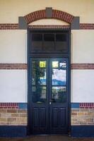 Vintage wooden door with glass panels and brick arch, perfect for historical architecture themes and classic design projects photo