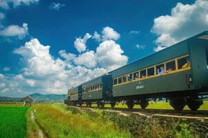A historic tourist train travels through the scenic countryside of Ambarawa, showcasing the region's rich heritage and natural beauty. Indonesia, 17 November 2024 photo