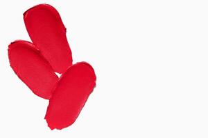 Range of red lipstick texture composition with empty space on a light white background. Cosmetic product smear smudge swatch sample. photo