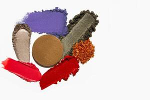Cosmetic product texture composition with lipstick, eyeshadow, bronzer, glitter, and powder with empty space on a light white background. photo