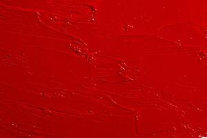 Texture of red lipstick covering the entire image. Bold cosmetic background, rich color. photo