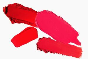 Lipstick strokes in red shades on a light white background. Cosmetic texture of matte lipstick smear. photo