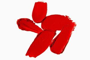 Red lipstick smudges and swatches in a textured composition on a light white background. Matte lipstick stroke design. photo