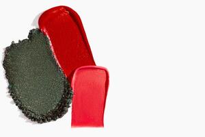 Colorful cosmetics texture composition with lipstick, eyeshadow, bronzer, glitter, and powder with empty space on a light white background. photo