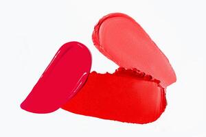 Textured strokes of lipstick in various red shades on a light white background. Cosmetic product smear sample. photo