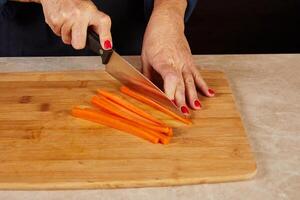 Slicing carrots into even sticks photo