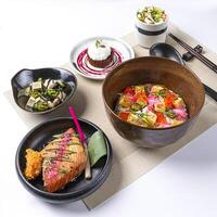 Truffle Soy Salmon Confit Bento Tofu seaweed salad served in broth and Chocolate lava cake ice cream isolated on napkin side view of Japanese food on white background photo