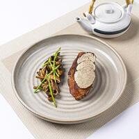Grilled Miso Cod topped with black truffle slice, sauteed mushrooms and asparagus served in plate isolated on napkin side view of Japanese food on white background photo