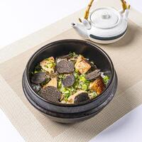 Black Truffle and Foie Grass Rice Donburi topped with fresh scallions served in broth with Teapot isolated on napkin side view of chinese food on white background photo