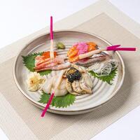 Sashimi Moriawase Platter including variety of raw fish slices such as salmon, shrimp, scallop, and white fish served in plate isolated on napkin side view of Japanese food on white background photo