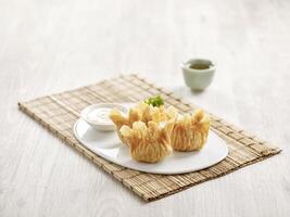 Deep fried Prawn Dumpling with Salad Sauce served in a tray isolated on mat side vie on grey background fast food photo
