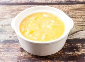 Chicken and corn soup served in broth isolated on wooden table side view of hong kong food photo